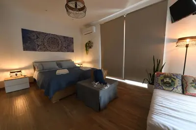 a bedroom with a bed and a couch at Terra Sinus Beautiful Suite in Terrasini
