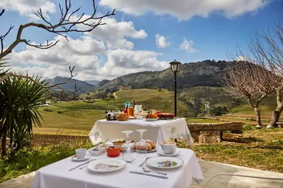a table with food on it with a view of a field at Helimos B&B with Segesta Temple view near Castellammare del Golfo in Calatafimi