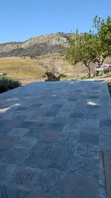 a stone patio with a mountain in the background at Helimos B&B with Segesta Temple view near Castellammare del Golfo in Calatafimi