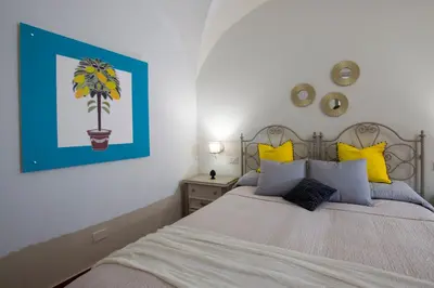 a bedroom with two beds with yellow pillows at Capo Rama Suites & Rooms in Terrasini