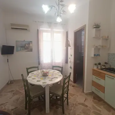 a kitchen and dining room with a table and chairs at Sicilia bedda 1 in Isola delle Femmine