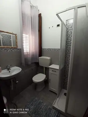 a bathroom with a toilet and a sink and a shower at Sicilia bedda 1 in Isola delle Femmine