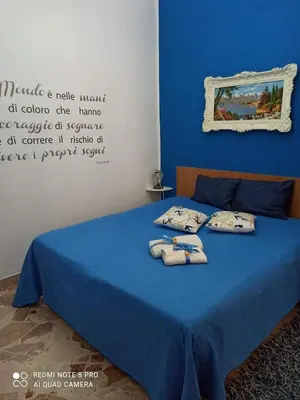 a bedroom with a blue bed with towels on it at Sicilia bedda 1 in Isola delle Femmine