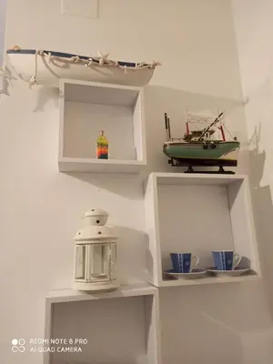 a shelf with a tea kettle and a toy boat on it at Sicilia bedda 1 in Isola delle Femmine