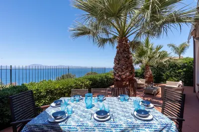 a table with a blue table cloth and palm trees at Splendida Villa con vista mozzafiato e piscina in Terrasini
