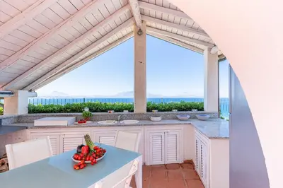 a kitchen with a table with a bowl of vegetables at Splendida Villa con vista mozzafiato e piscina in Terrasini