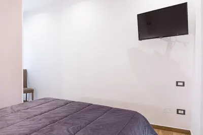 a bedroom with a bed and a flat screen tv on the wall at Casa Vacanze del Corso in Bagheria