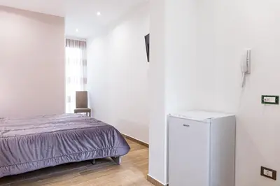 a bedroom with a bed and a refrigerator at Casa Vacanze del Corso in Bagheria