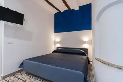 a bed in a room with a blue and white wall at Monolocali Leonardo in Castellammare del Golfo