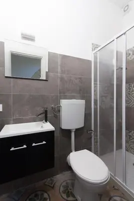 a bathroom with a toilet and a sink and a shower at Monolocali Leonardo in Castellammare del Golfo