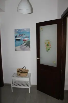 a room with a door and a bench and a painting at La Casa di Andly in Palermo