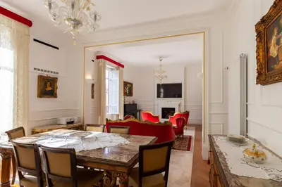 a dining room with a table and a living room at Le Rose di Nonna Maria, appartamento di lusso in centro città in Palermo