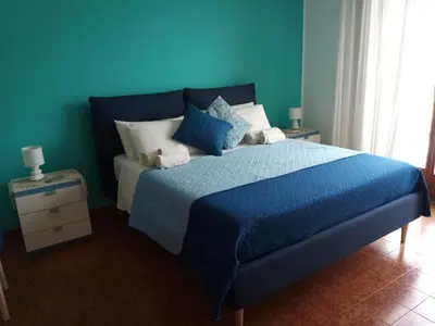 a blue bedroom with a bed with blue sheets and pillows at Casa Rosamarina in Mondello