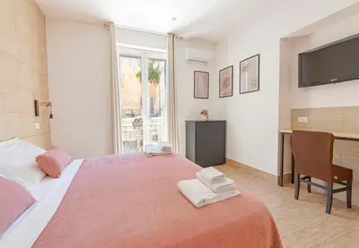 a bedroom with a large bed with a desk and a television at La Ciconella in Palermo
