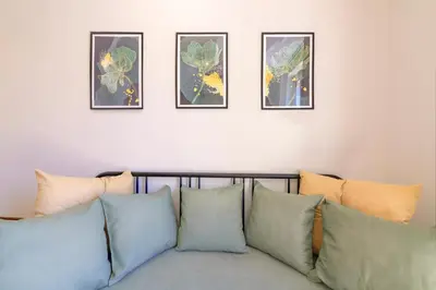 a couch with four framed pictures on a wall at La Ciconella in Palermo