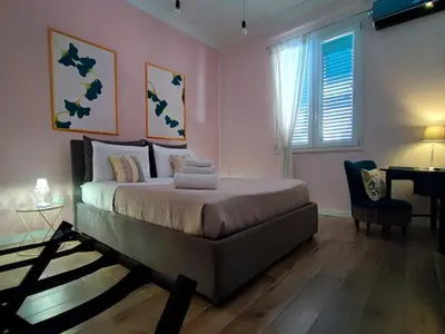 a bedroom with a bed and a desk and a window at Casa del Capo in Palermo