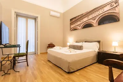 a bedroom with a bed and a table and a desk at Divisi Suites & SPA in Palermo
