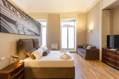 a room with a bed and a couch and a television at Divisi Suites & SPA in Palermo