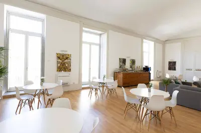 a living room with tables and chairs and a couch at Divisi Suites & SPA in Palermo