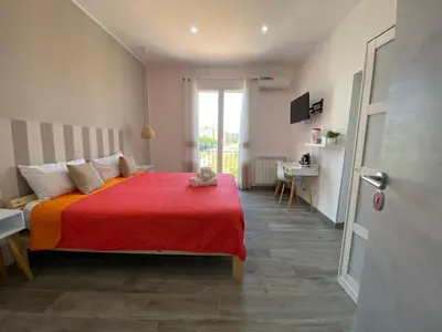 a bedroom with a large bed with a red blanket at La Piccola Formica Charme Rooms in Palermo