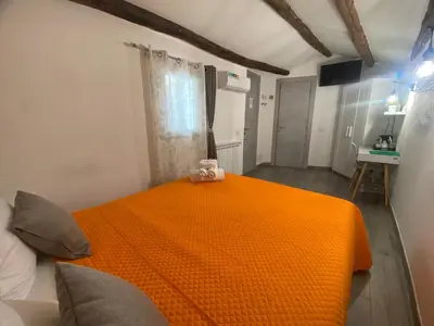 a bedroom with an orange bed with a teddy bear on it at La Piccola Formica Charme Rooms in Palermo
