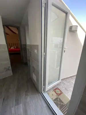 a walk in shower in a room with a glass door at La Piccola Formica Charme Rooms in Palermo