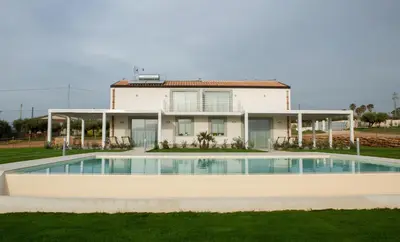 a house with a swimming pool in front of a house at Case Playa Resort in Balestrate