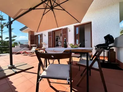 a patio with an umbrella and a table and chairs at Casa Villea in Trabia