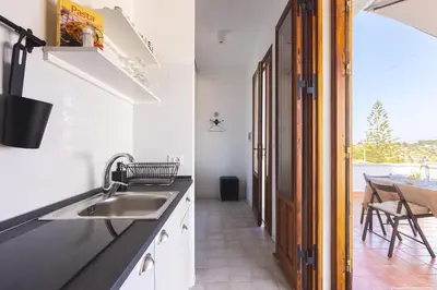 a kitchen with a sink and a dining room at Casa Villea in Trabia