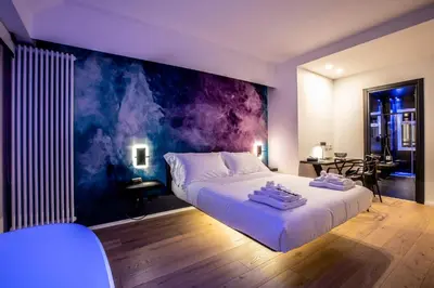 a bedroom with a large white bed with a painting on the wall at Miceli Exclusive Suite in Palermo