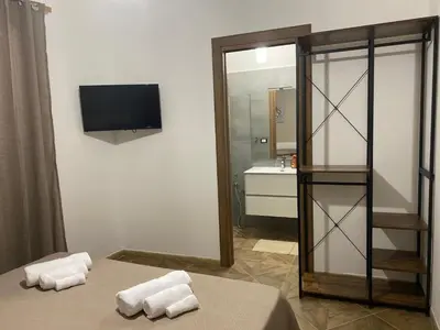 a bathroom with a bed and a sink and a mirror at DREAM CORLEONE ONE in Corleone