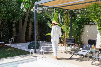 a mannequin in a hat standing next to a pool at Domìa Boutique Hotel e Cucina in Mondello