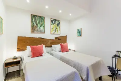 two beds in a room with white and red pillows at Mama Tita Rooms and Breakfast in Palermo