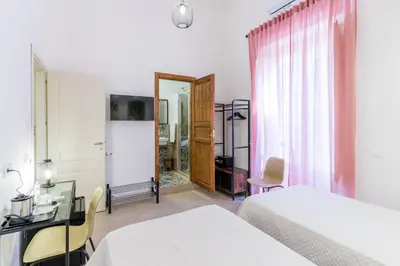 a hotel room with two beds and a mirror at Mama Tita Rooms and Breakfast in Palermo