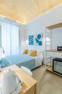 a bedroom with a bed and a desk and a table at Mama Tita Rooms and Breakfast in Palermo