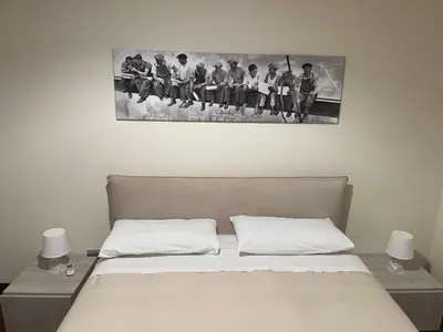 a bedroom with a bed and a picture of a group of people at Anna's Luxury Apartment in Palermo