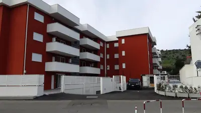 a red building with a white fence in a parking lot at DIMENTICA IL CERVELLO in Palermo