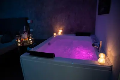 a purple bath tub with candles in a room at Fervore Luxury Rooms in Palermo