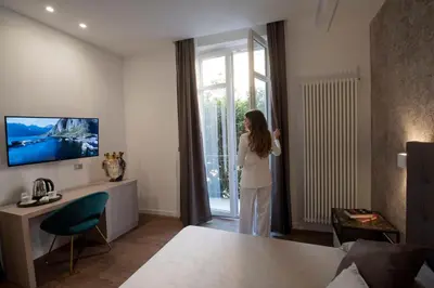 a woman standing in a living room looking out the window at Fervore Luxury Rooms in Palermo