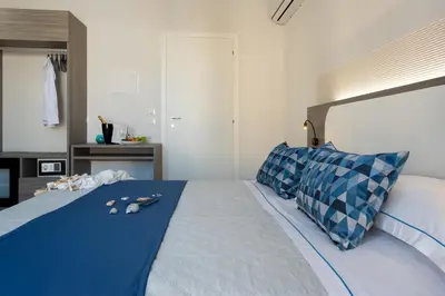 a bedroom with a large bed with blue sheets and pillows at Scrusciu du mari in San Vito lo Capo