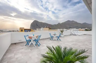 a patio with chairs and tables on a roof at Scrusciu du mari in San Vito lo Capo