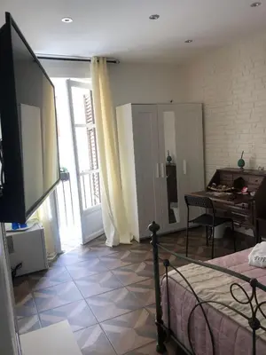 a room with a bed and a table and a television at nonno peppe in Palermo