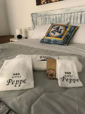 a bed with two white towels on top of it at nonno peppe in Palermo