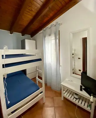 a bedroom with two bunk beds and a mirror at Villa Marcione Garden & House in Cinisi