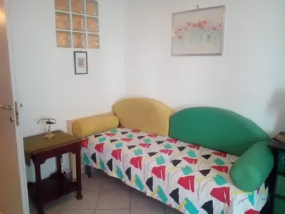a small bed in a room with a table at La Casetta di Dafne in Palermo