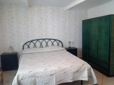 a bedroom with a bed and a green dresser at La Casetta di Dafne in Palermo