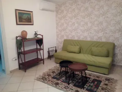 a living room with a green couch and a table at La Casetta di Dafne in Palermo