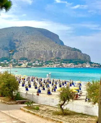 a beach with a bunch of chairs and the ocean at L'Angolino di Anna in Mondello