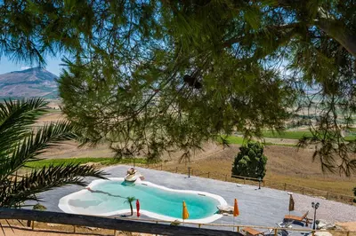 a person is sitting in a swimming pool at Agriturismo Antichi Granai in Calatafimi