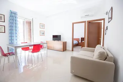 a living room with a couch and a table and chairs at Casa in centro in Castellammare del Golfo